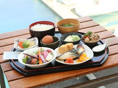 un vassoio di cibo su un tavolo con ciotole di cibo di Hotel Marinoa Resort Fukuoka a Fukuoka