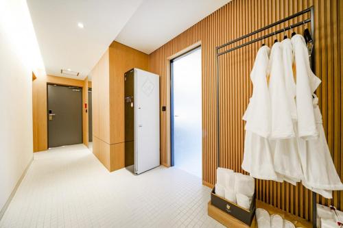 a corridor of a hotel room with white clothes at Haeundae The Van Hotel in Busan
