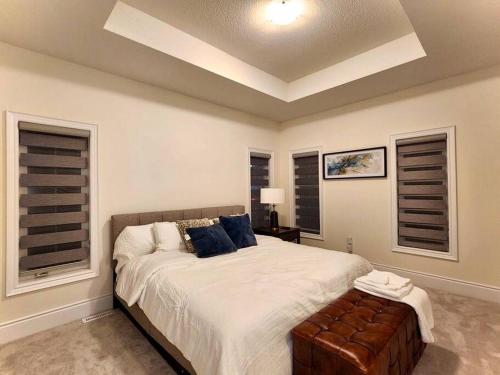 ein Schlafzimmer mit einem großen Bett und blauen Kissen in der Unterkunft Luxury, Home Away from Home in Brampton