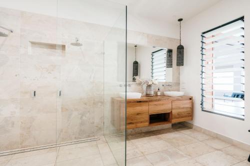 a bathroom with a glass shower and a sink at Novo Luxury Apartment Penguin Accommodation Itas in Penguin