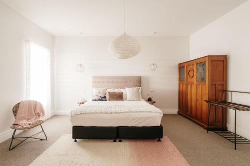 a bedroom with a large bed and a chair at Novo Luxury Apartment Penguin Accommodation Itas in Penguin
