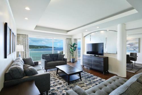 a living room with a couch and a television at Hoshino Resorts RISONARE Guam in Tamuning
