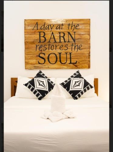 a board above a bed with a sign on it at D'Barn Hostel in Panglao Island
