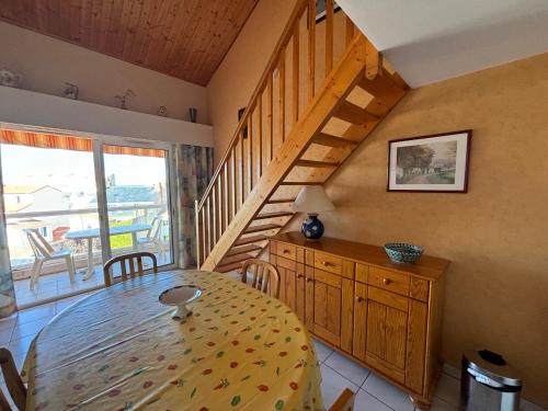 une salle à manger avec une table et un escalier dans l'établissement Appartement T3 - à 50m de la plage, 2 chambres, garage - FR-1-197-225, à Les Sables-dʼOlonne