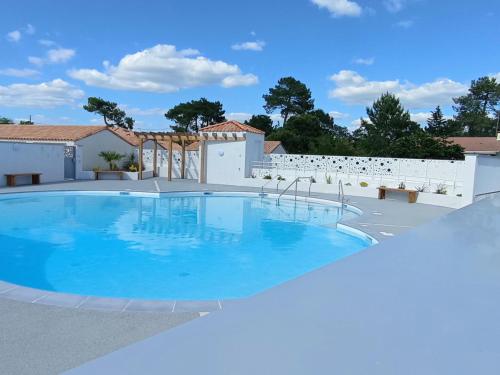 - une piscine dans une villa avec ciel bleu dans l'établissement Maison avec piscine proche plage, La Tranche-sur-Mer - FR-1-22-345, à La Tranche-sur-Mer