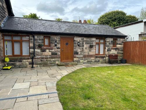 a small stone house with a yard in front of it at The Coachmans Cottage in Rock Ferry