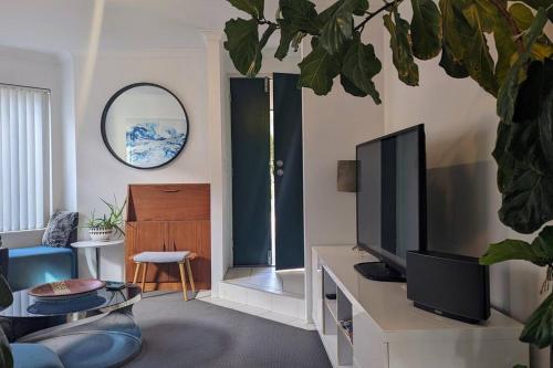 a living room with a flat screen tv on a table at Ocean Villa in Perth