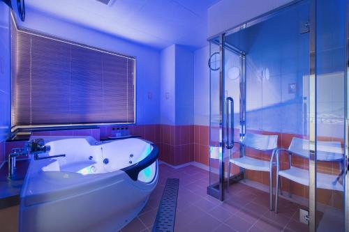 a large bathroom with a tub and a shower at Hotel BAMBOO in Iizuka
