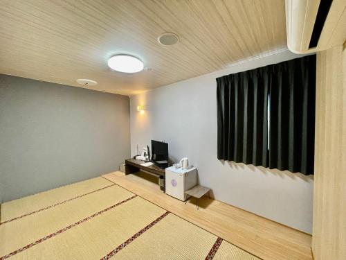 a living room with a television and a window at Hotel Select Inn Saitama Moroyama in Ogose