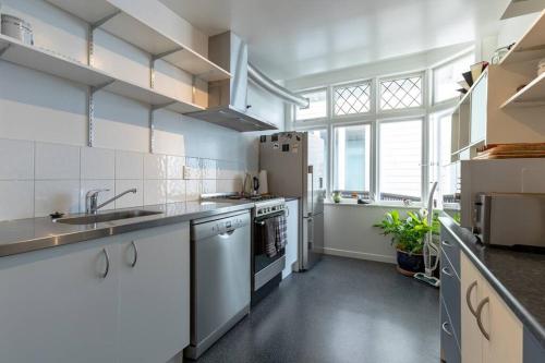 a kitchen with white appliances and a large window at Ideal location for groups, family, friends or work in Wellington
