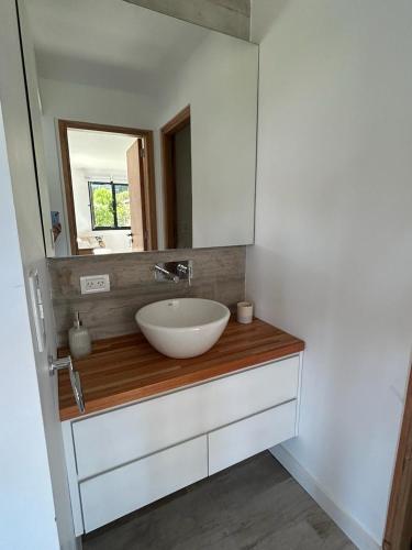 a bathroom with a white sink and a mirror at Casa Nera Chica in Chapadmalal
