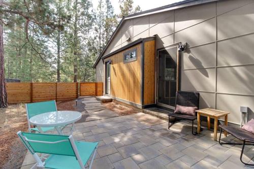 a patio with a table and chairs next to a building at Serendipitous-AC, Hot Tub, Big Fenced Yard, 2 Master Suites, in Bend