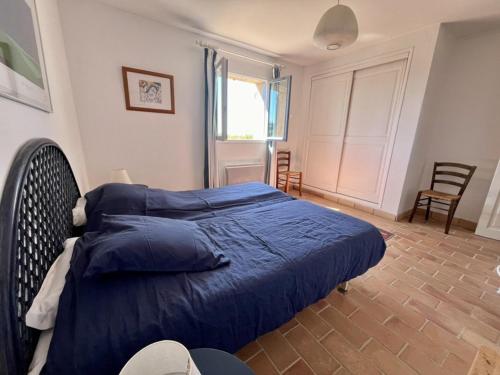 une chambre avec un lit avec une couette bleue dans l'établissement Maison spacieuse avec piscine, Wi-Fi et climatisation à La Croix-Valmer - FR-1-226B-204, à La Croix-Valmer