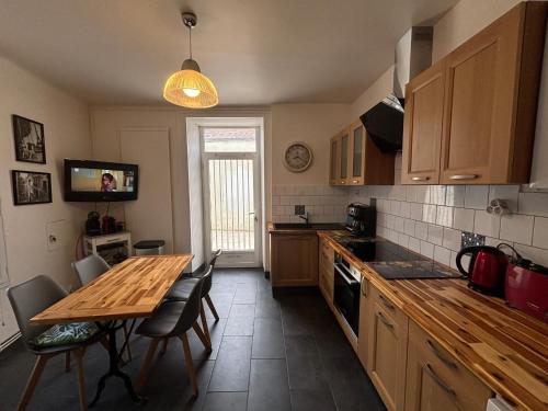 une cuisine avec une table en bois et une table et des chaises dans l'établissement Maison 4 chambres, 2 étoiles, près plage, port de pêche – Les Sables-d'Olonne - FR-1-197-605, à Les Sables-dʼOlonne