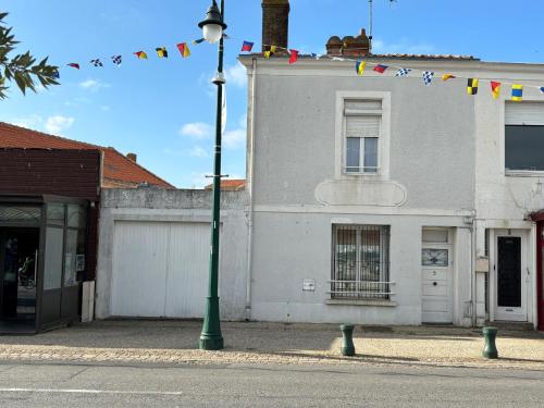 un feu de rue devant un bâtiment arborant des drapeaux dans l'établissement Maison 4 chambres, 2 étoiles, près plage, port de pêche – Les Sables-d'Olonne - FR-1-197-605, à Les Sables-dʼOlonne