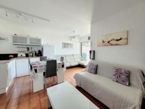 un salon avec un canapé et une cuisine dans l'établissement Canet-en-Roussillon - 4 personnes - T2 - Parking privé - Climatisation - FR-1-794-102, à Canet