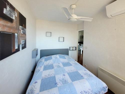 une chambre avec un lit avec un ventilateur de plafond dans l'établissement Canet-en-Roussillon - 4 personnes - T2 - Parking privé - Climatisation - FR-1-794-102, à Canet