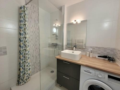 une salle de bain avec un lavabo et une machine à laver dans l'établissement Canet-en-Roussillon - 4 personnes - T2 - Parking privé - Climatisation - FR-1-794-102, à Canet