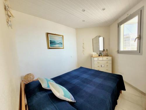 une chambre avec un lit bleu et une fenêtre dans l'établissement Canet-en-Roussillon T2, 4 pers, Clim, face mer - FR-1-794-106, à Canet