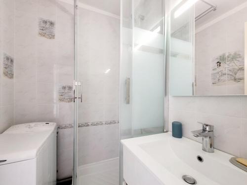 une salle de bain blanche avec un lavabo et une douche dans l'établissement Canet-en-Roussillon T2, 4 pers, Clim, face mer - FR-1-794-106, à Canet