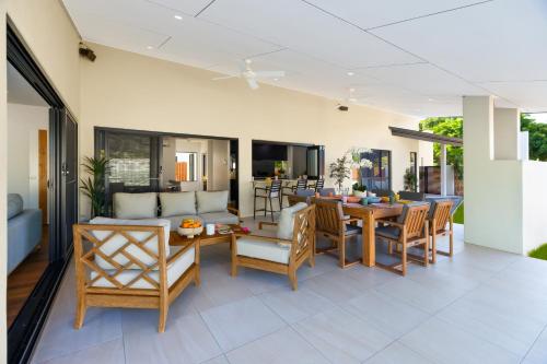 an open living room with a table and chairs at Luxury Sunny Oasis with Pool, SUV Hire, Near Marina in Trinity Beach