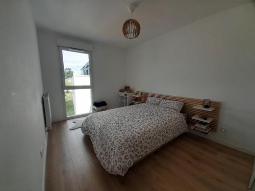 une chambre avec un lit et une fenêtre dans l'établissement T2 moderne avec terrasse ensoleillée et parking au centre d'Anglet, proche des plages - FR-1-239-1063, à Anglet