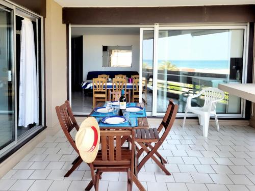 une salle à manger avec une table et des chaises sur un balcon dans l'établissement Canet-en-Roussillon : T3 6 pers accès plage, parking, terrasse - FR-1-794-99, à Canet
