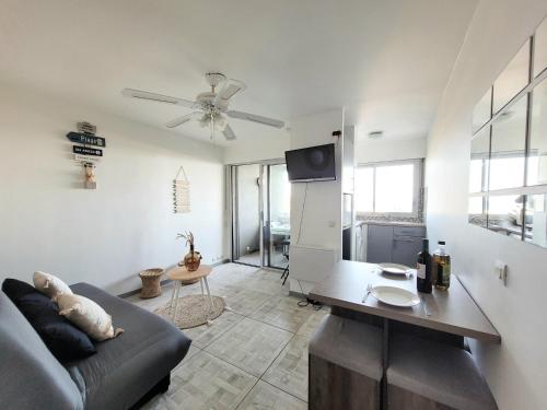 un salon avec un canapé et une table dans l'établissement Canet-en-Roussillon - T2 moderne 4 pers, accès direct plage, terrasse vue mer - FR-1-794-103, à Canet