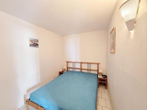 une chambre avec un lit avec une couverture bleue dans l'établissement Canet-en-Roussillon : T3 6 pers accès plage, parking, terrasse - FR-1-794-99, à Canet