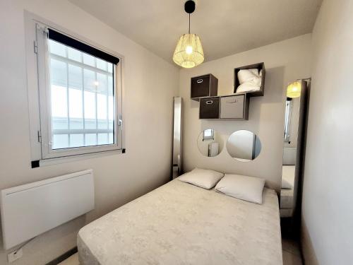 une petite chambre avec un lit et une fenêtre dans l'établissement Canet-en-Roussillon - T2 moderne 4 pers, accès direct plage, terrasse vue mer - FR-1-794-103, à Canet