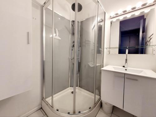 une salle de bain blanche avec une douche et un lavabo dans l'établissement Canet-en-Roussillon : T3 6 pers accès plage, parking, terrasse - FR-1-794-99, à Canet