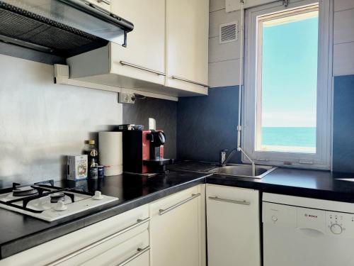 Il comprend une cuisine équipée d'une cuisinière et d'un évier. dans l'établissement Canet-en-Roussillon : T3 pour 6 pers, Parking, Wifi, Animaux admis - FR-1-794-111, à Canet