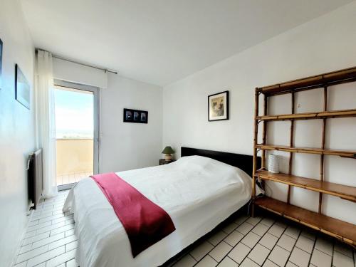 une chambre avec un grand lit et une fenêtre dans l'établissement Canet-en-Roussillon : T3 pour 6 pers, Parking, Wifi, Animaux admis - FR-1-794-111, à Canet