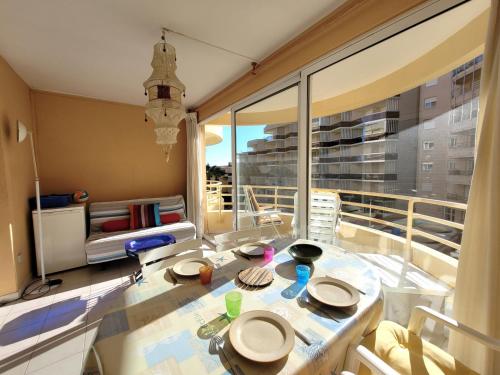 un salon avec une table et une grande fenêtre dans l'établissement Beau T3 traversant - Front de mer - 100m Plage - Parking privé - 2ème étage - FR-1-794-112, à Canet