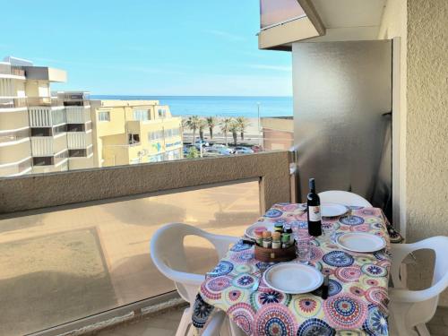 - une table avec une bouteille de vin assise sur un balcon dans l'établissement Canet-en-Roussillon T2 - 3 pers, Front de Mer, Ascenseur - FR-1-794-117, à Canet
