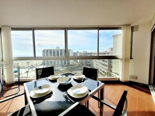 une salle à manger avec une table et une grande fenêtre dans l'établissement Canet-en-Roussillon - T2 Alcôve - 4 pers - Parking - Loggia - Ascenseur - 1 étoile - FR-1-794-119, à Canet