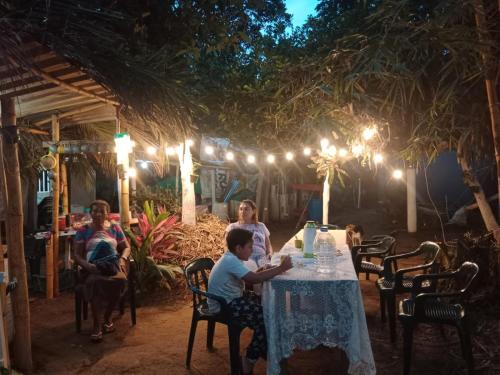 un grupo de personas sentadas en una mesa por la noche en Eco Hospedaje Ata Ladrilleros, en Buenaventura