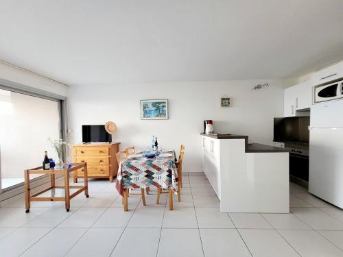 une cuisine avec une table et une cuisine avec des appareils électroménagers blancs dans l'établissement Canet Sud - T2 cabine 4/6 pers - Terrasse - Accès direct plage - FR-1-794-121, à Canet