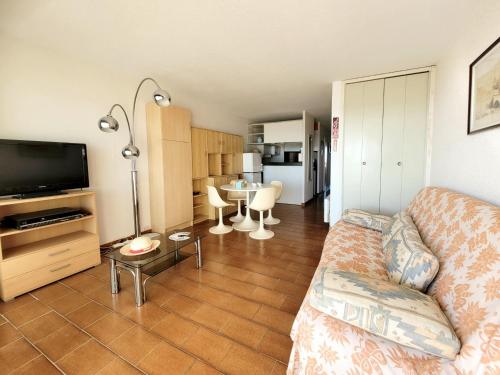 un salon avec un canapé, une télévision et une table dans l'établissement Canet-en-Roussillon - T2 lumineux pour 4 pers, terrasse, parking privé, plage à 50m - FR-1-794-114, à Canet