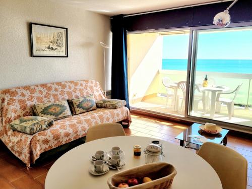 un salon avec un canapé et une table dans l'établissement Canet-en-Roussillon - T2 lumineux pour 4 pers, terrasse, parking privé, plage à 50m - FR-1-794-114, à Canet