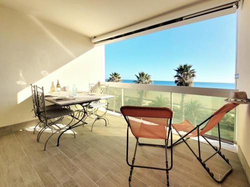 un balcon avec une table et des chaises et une vue sur l'océan dans l'établissement Canet-en-Roussillon: T2 moderne avec terrasse, parking privé et ascenseur pour 4 pers - FR-1-794-129, à Canet