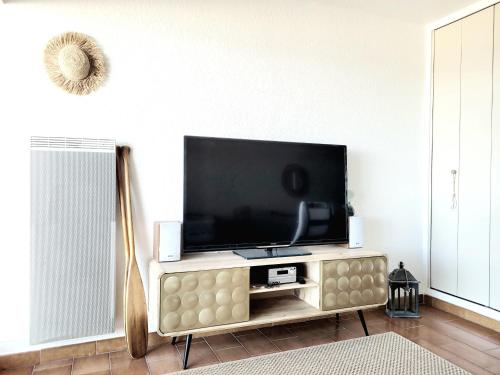 un salon avec une télévision à écran plat sur un centre de divertissement dans l'établissement Canet-en-Roussillon: T2 moderne avec terrasse, parking privé et ascenseur pour 4 pers - FR-1-794-129, à Canet