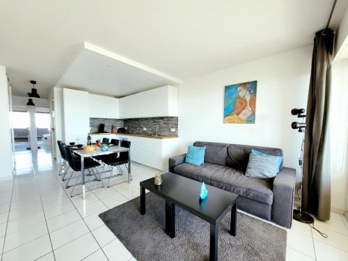 un salon avec un canapé et une table dans l'établissement Canet-en-Roussillon - 6 pers - T3 - Plage directe, PKG, Piscine, Wifi - FR-1-794-128, à Canet