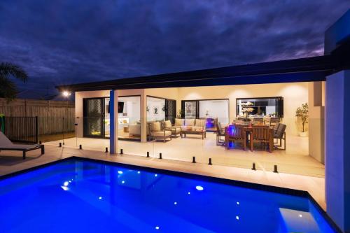 a house with a swimming pool at night at Luxury Sunny Oasis with Pool, SUV Hire, Near Marina in Trinity Beach