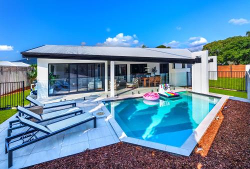 a swimming pool in a backyard with a house at Luxury Sunny Oasis with Pool, SUV Hire, Near Marina in Trinity Beach