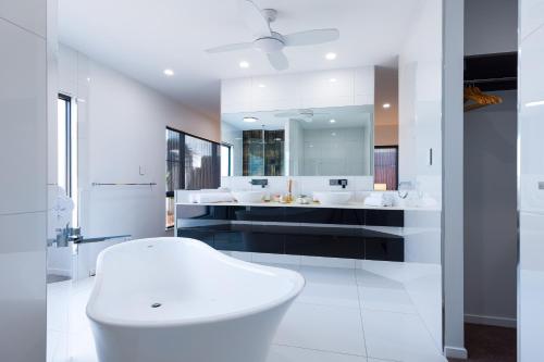 a bathroom with two sinks and a large mirror at Luxury Sunny Oasis with Pool, SUV Hire, Near Marina in Trinity Beach