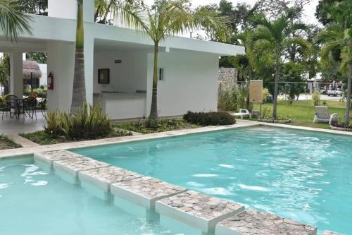 a swimming pool in front of a house at El Faro 2bed 1 bath gated neighborhood with pool in Puerto Morelos