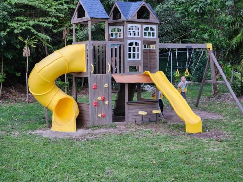 a small playground with a slide and a swing at El Faro 2bed 1 bath gated neighborhood with pool in Puerto Morelos