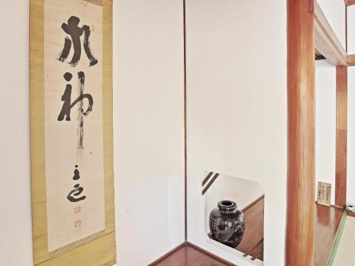 a display case with a vase in a room at GUESTHOUSE & SAUNA 杜（mori） in Kushimoto