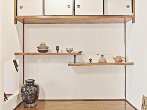 a shelf with pottery and other items on it at GUESTHOUSE & SAUNA 杜（mori） in Kushimoto